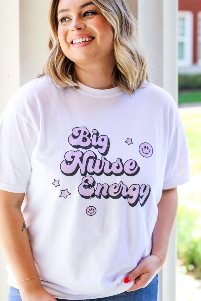 White tee with "Big Nurse Energy" in bubble letters in pink 