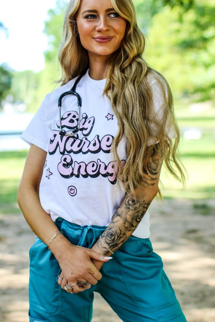 White tee with "Big Nurse Energy" in bubble letters in pink 