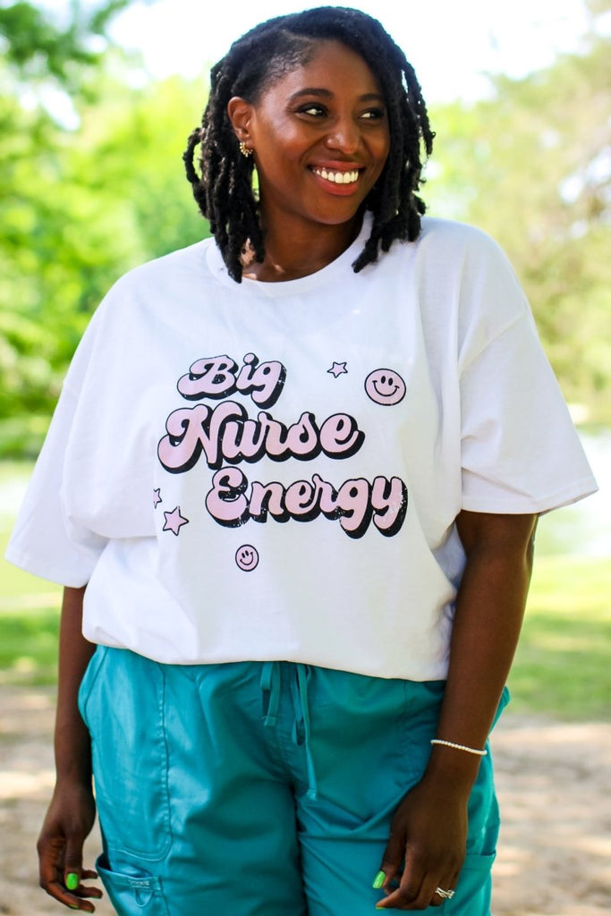 White tee with "Big Nurse Energy" in bubble letters in pink 