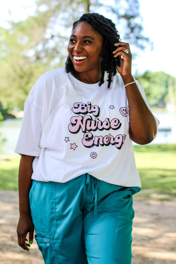 White tee with "Big Nurse Energy" in bubble letters in pink 