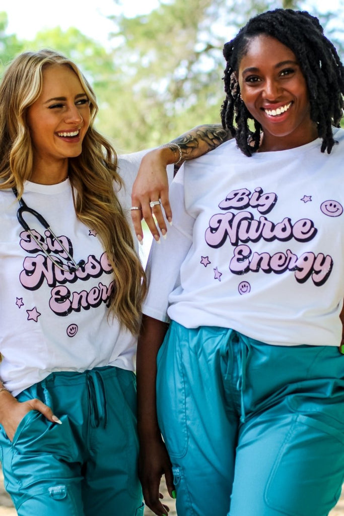 White tee with "Big Nurse Energy" in bubble letters in pink 